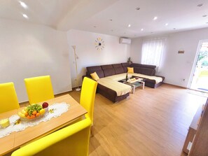 Ein modernes Wohnzimmer mit einer Couch, einem Esstisch und Stühlen.