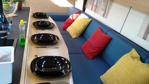 Un espacio habitable compacto con comedor, un sofá con cojines y un ventanal con tragaluz.