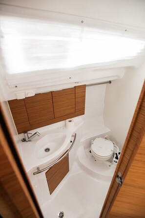 A compact bathroom with a toilet, sink, and shower. - Sun-Kissed Sailing Adventure in Zadar, Croatia (Zadar)