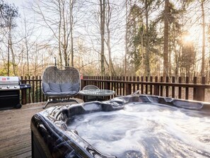 A hot tub on a wooden deck with a grill and seating area. - Cropton Golden Oak (Pickering)