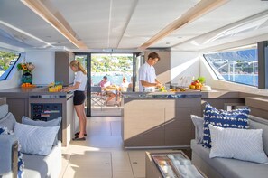 A yacht interior with a kitchen, dining area, and seating.