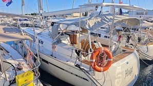Un puerto deportivo con varios veleros amarrados, incluyendo uno llamado 'Hugo'.
