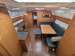 Un espacio interior compacto con una mesa de comedor, sofá y kitchenette.