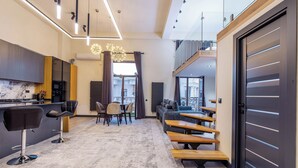 A modern interior with a kitchen, dining area, and seating with a view.