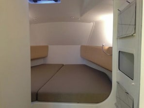 A compact interior with a bed, a small table, and a window.
