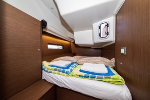 Una cabaña pequeña con cama, un ventanal y aire acondicionado integrado.