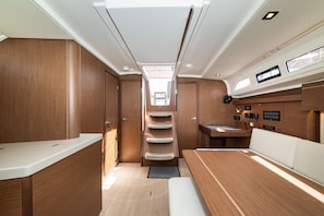 Un intérieur compact avec un escalier central, un coin repas et une petite cuisine.