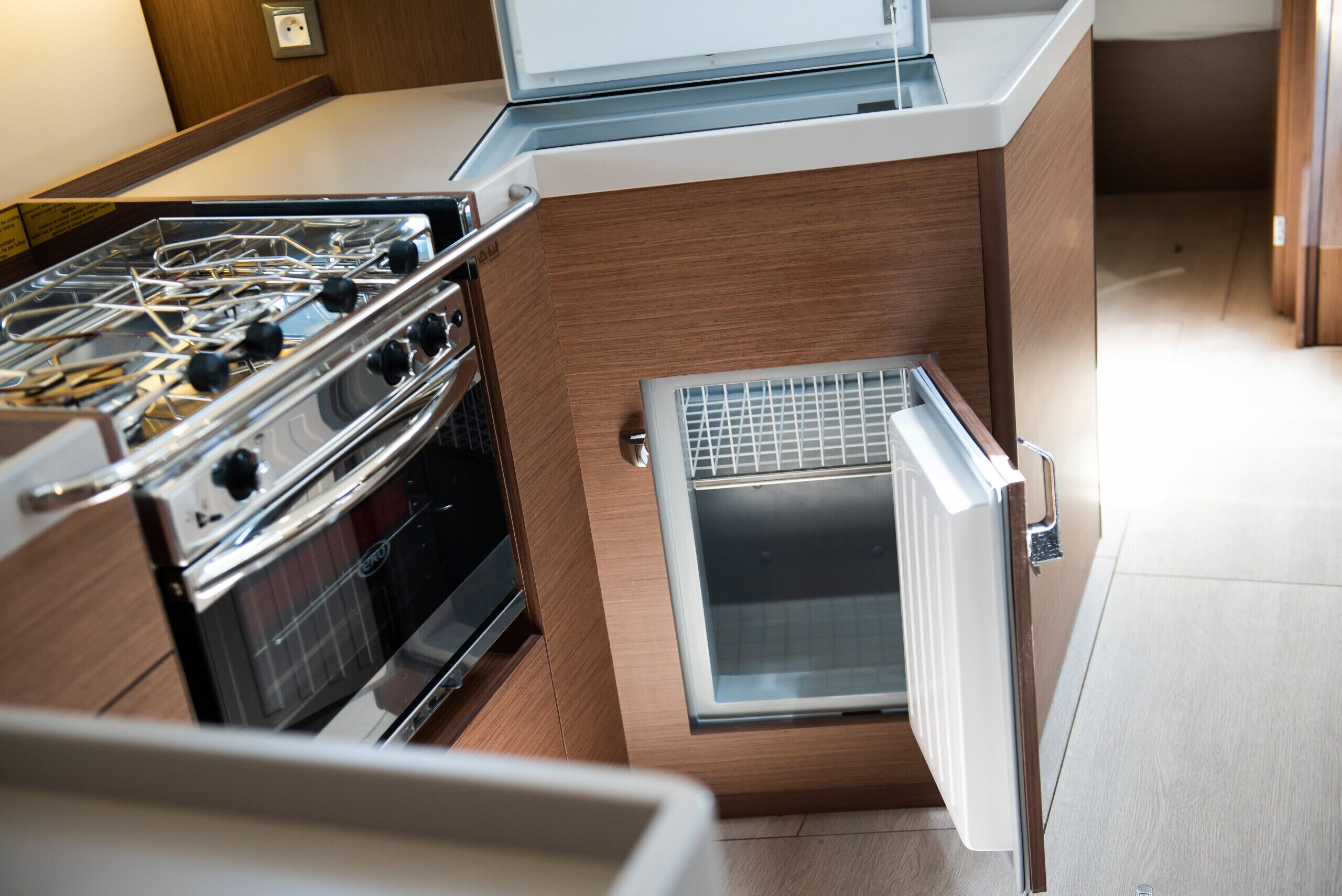 Een praktische keuken met een inbouwfornuis, oven en een kleine koelkast.