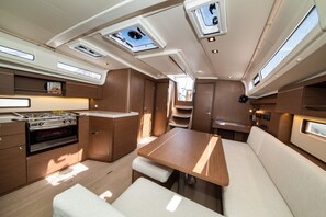 A compact kitchen with a stove, oven, and built-in seating area. - Sun-Kissed Sailing Adventure in Zadar, Croatia (Zadar)