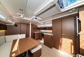 A compact kitchen with a dining area, built-in cabinets, and a small window. - Sun-Kissed Sailing Adventure in Zadar, Croatia (Zadar)