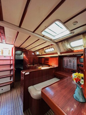 A compact galley with a sink, a small seating area, and a control panel. - Sun-Kissed Sailing Adventure in Islas Sarónicas (Alimos)