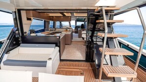Bootinterieur met een keuken, zithoek en uitzicht op zee.