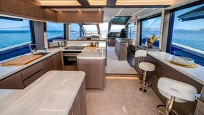 Een modern jachtinterieur met een keuken, bar en zithoek.
