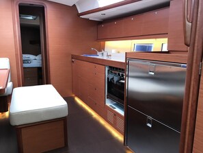 Eine kompakte Küche mit Backofen, Kühlschrank und Spüle.