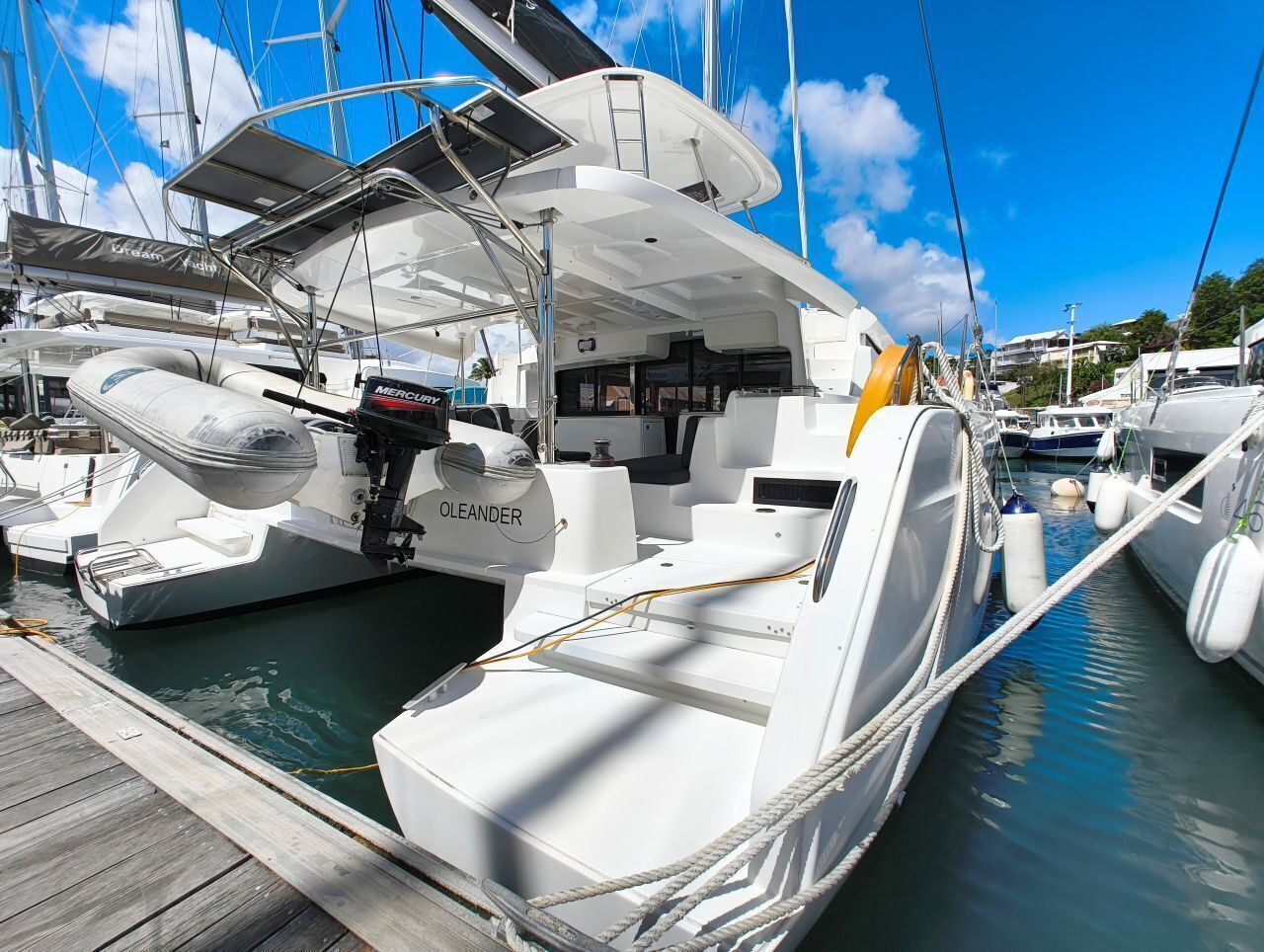 A marina with multiple yachts docked, including one with 'OLEANDER' branding.
