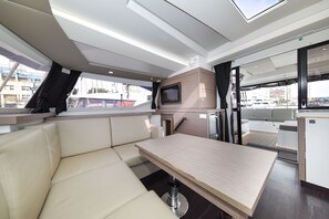 A modern interior with a dining area, a television, and a view of the outside. - Sun-Kissed Sailing Adventure in Zadar, Croatia (Zadar)