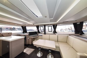 Ein modernes Interieur mit Küchenbereich, Sitzgelegenheiten und großen Fenstern.
