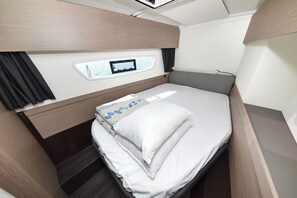 A compact, well-lit bedroom with a bed, a small window with a view, and a control panel on the wall. - Sun-Kissed Sailing Adventure in Zadar, Croatia (Zadar)