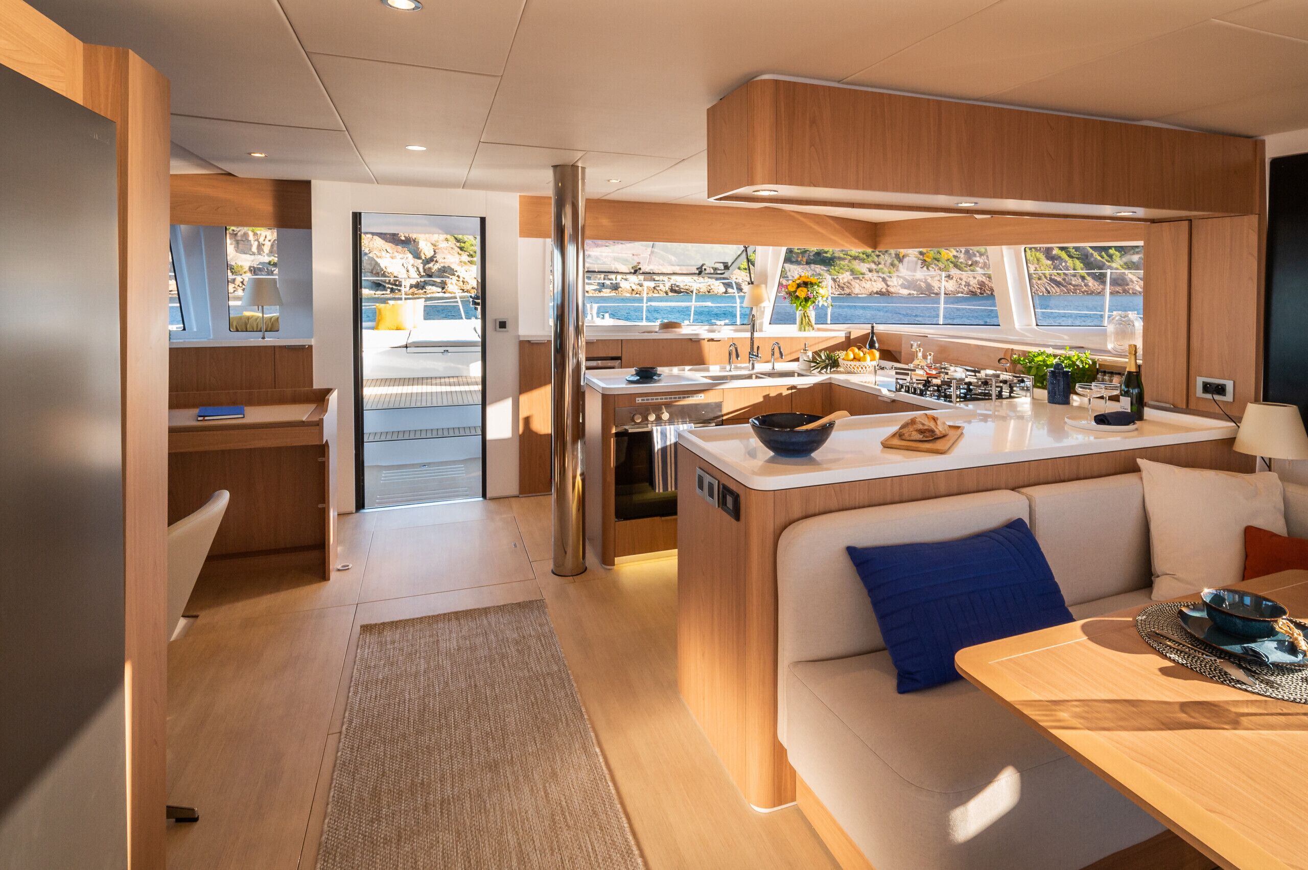 Un intérieur moderne comprenant une cuisine, un coin repas et une vue sur la mer.