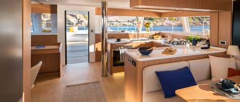 A modern interior with a kitchen, dining area, and a view of the sea.