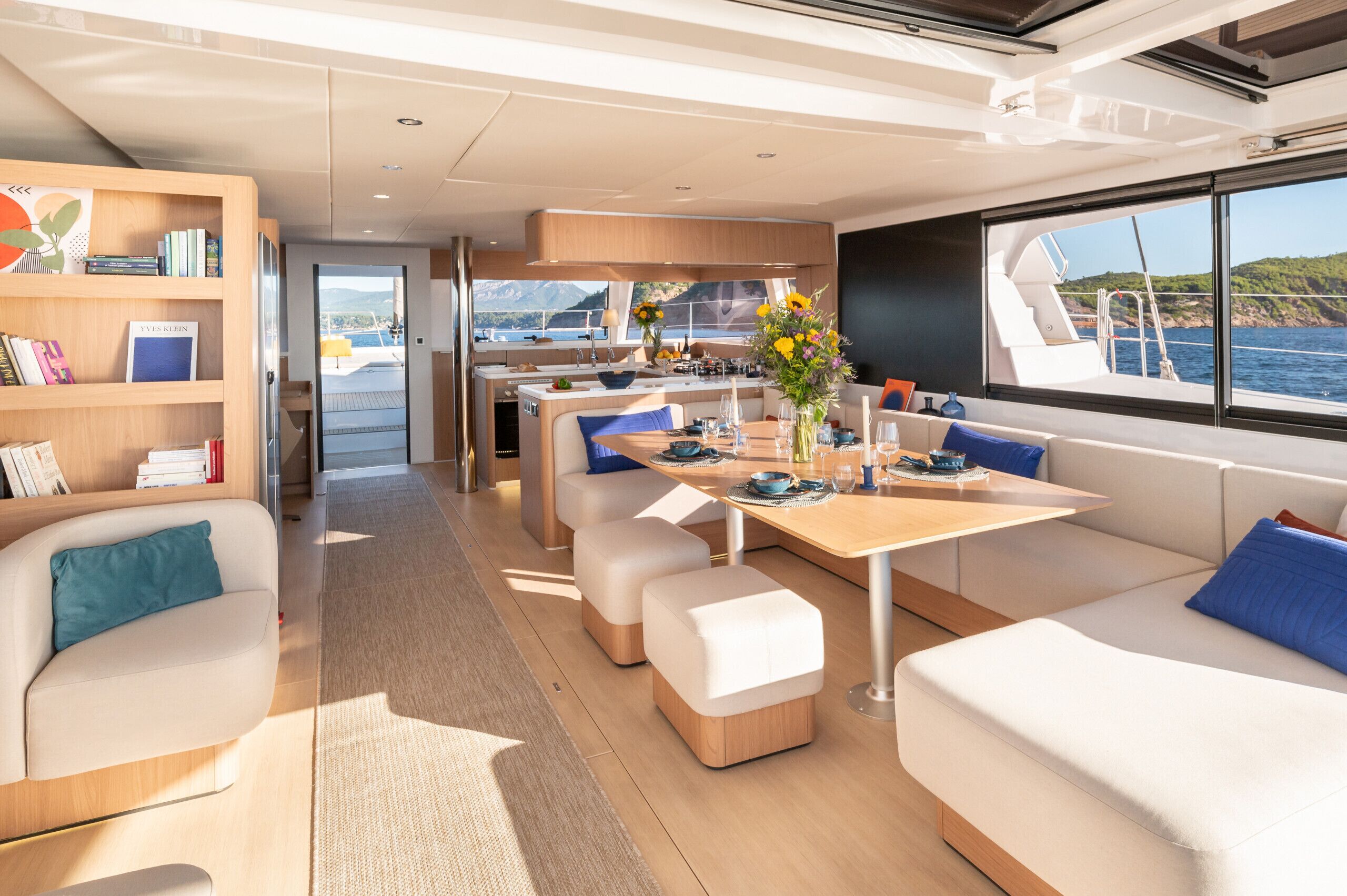 Un intérieur moderne comprenant un coin repas, des sièges et une vue sur la mer.