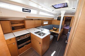 A compact galley with a sink, stove, and storage cabinets.