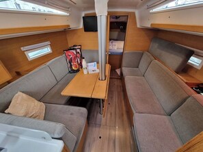 A compact interior with a sofa, a small table, a television, and a storage cabinet.