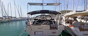 A marina with multiple sailboats docked, featuring a boat named 'Bianco' with a covered deck area.