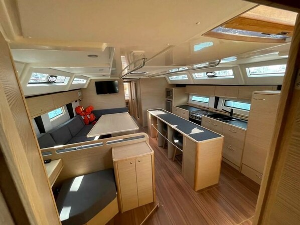 A compact RV interior with a kitchenette, seating area, and a small table.