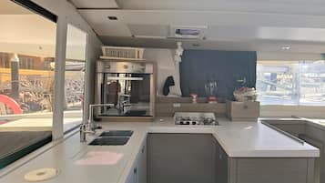 Eine moderne Küche mit eingebautem Backofen, einer Spüle und einem Fenster mit Blick auf eine Baustelle.