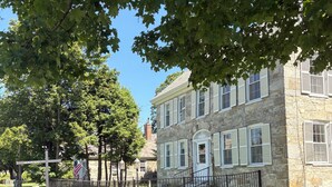 A stone building with a stone fence, a grassy area, and a street sign. - Cozy 1-bedroom studio in Historic Stone Village of Chester (Chester)