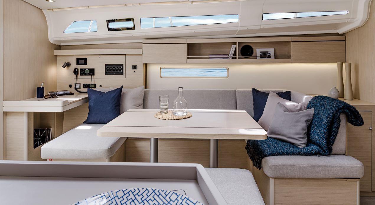 Un intérieur compact comprenant une table, des sièges rembourrés, un panneau de commande et une fenêtre.