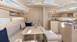 Een compact interieur met een eethoek, een kitchenette en een zithoek met uitzicht.
