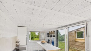 Una cocina moderna con un ventanal grande, una mesa de comedor y vistas al exterior.