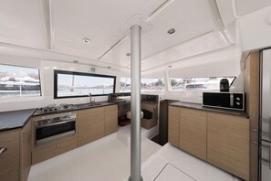 Eine moderne Küche mit einem großen Fenster, einem eingebauten Backofen und einer Mikrowelle.