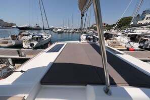 Ein Yachthafen mit mehreren vertäuten Booten, wolkenlosem Himmel und ruhiger See.