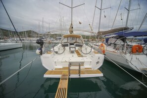A marina with a white yacht docked, featuring a steering wheel, life rings, and a wooden deck. - Sun-kissed Sailing Adventure in Split-Dalmatia, Croatia (Seget Donji)
