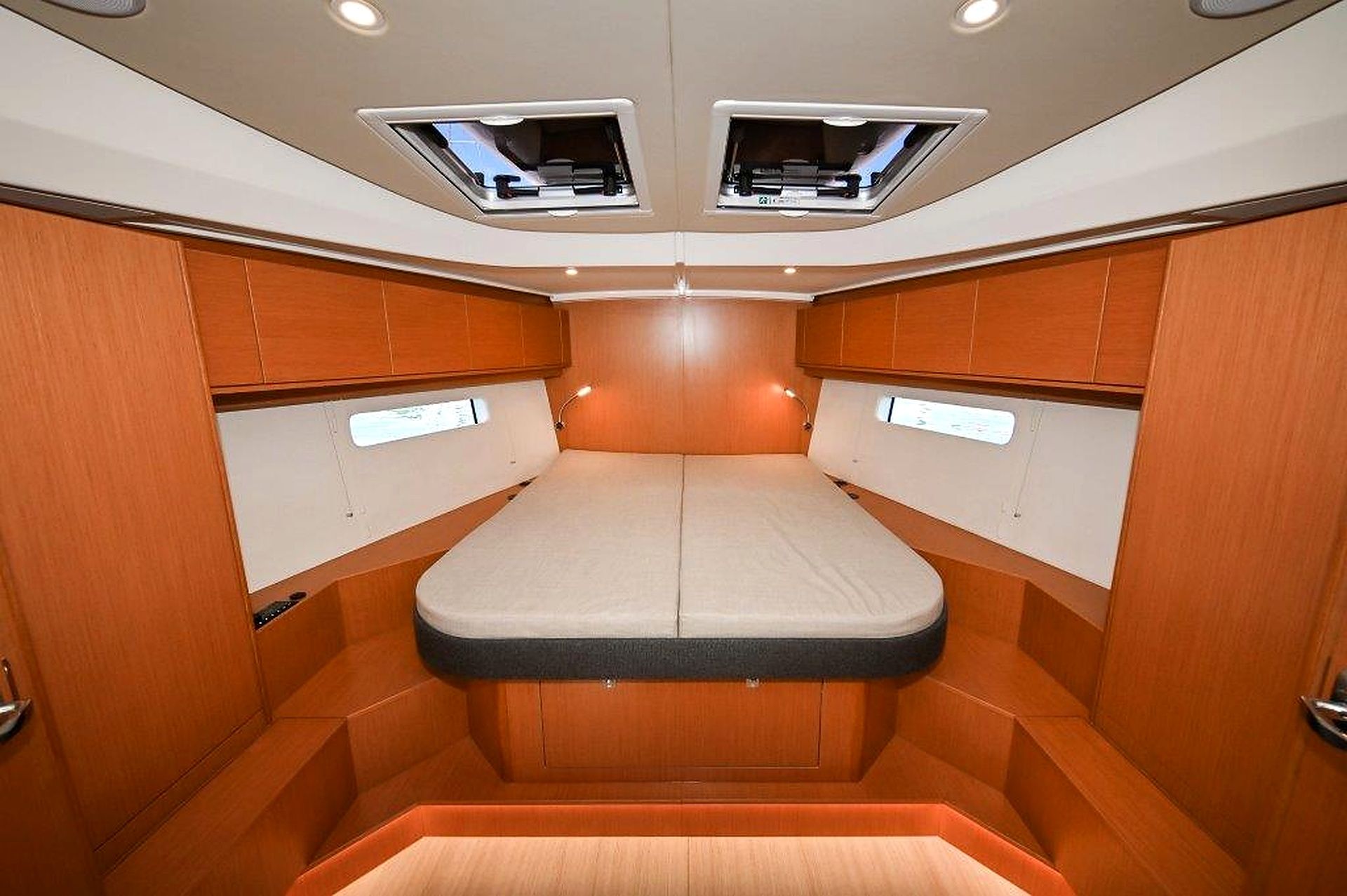 Een knus vakantiehuisje met een enkel bed, houten lambrisering en verlichting in het plafond.