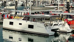 A white yacht docked at a marina with multiple boats, a covered area, and a clear view of the water. - Sun-Kissed Sailing Adventure in Gran Barrera de Coral from Playa Airlie, Queensland (Airlie Beach)