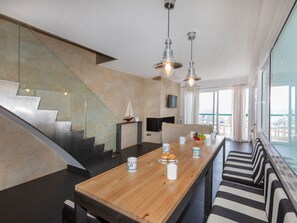 A modern kitchen with a wooden island, stainless steel appliances, and a large window overlooking a balcony. - Punta Aromir by Interhome (Tossa de Mar)