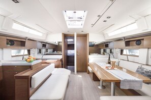 A compact RV interior with a kitchenette, a dining area, and a seating space. - Sun-Kissed Sailing Adventure in the Dodecanese Islands (Kos)