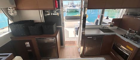 A compact galley with a map, a refrigerator, and a stove.