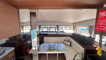 A compact kitchen area with a dining table, a fire extinguisher, and a map on the table.