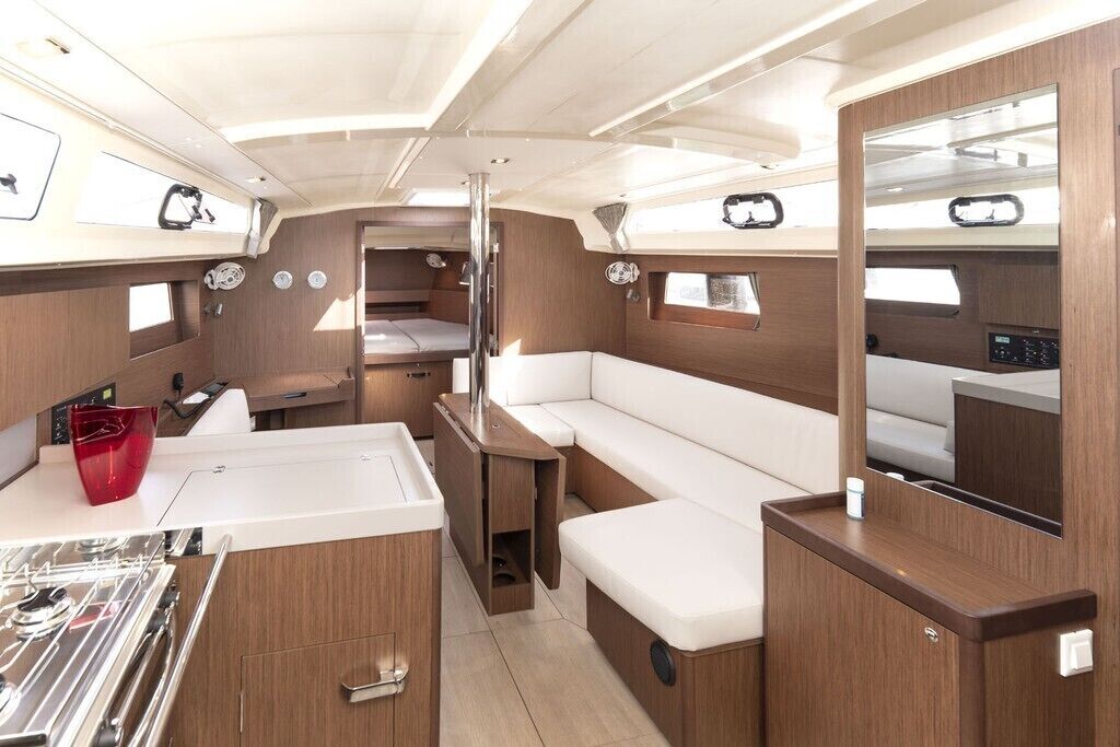 A compact interior with a kitchenette, a seating area, and a small bed.