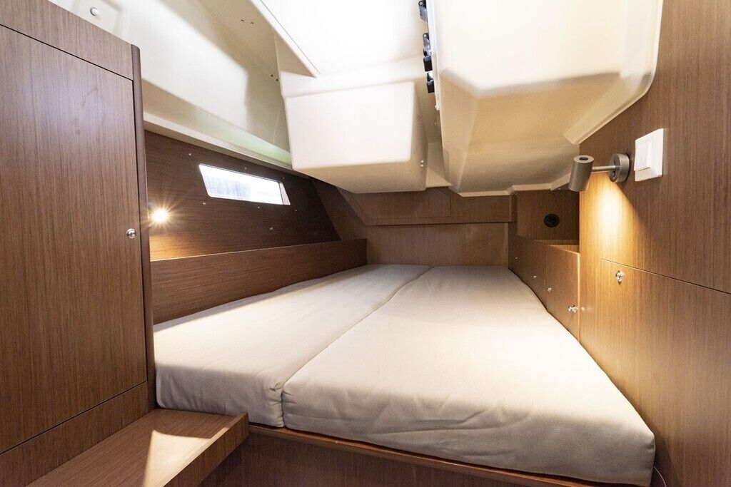 Ein gemütliches, helles Blockhaus mit einem Einzelbett, Holzvertäfelung und einem Oberlicht.