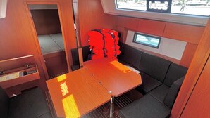 Un interior pequeño con una mesa, asientos acolchados, una ventana y un panel de control.