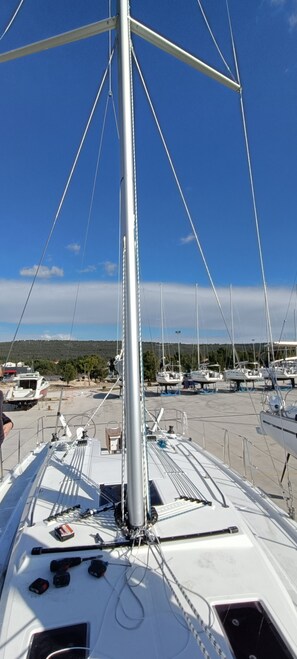 Das Deck eines Segelbootes mit Mast, Takelage und diverser Ausrüstung.