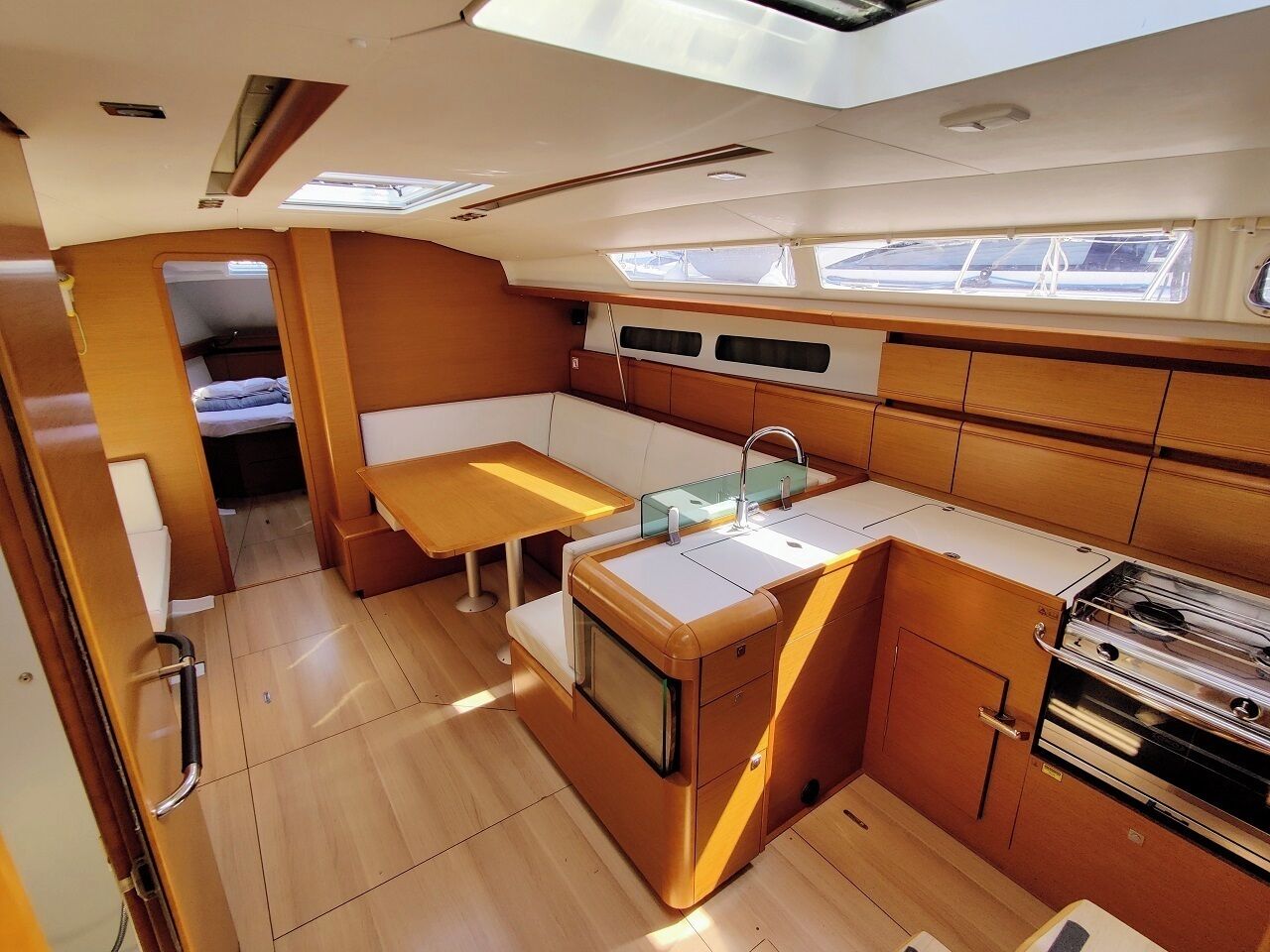 A compact kitchen with a sink, stove, and a small dining area.