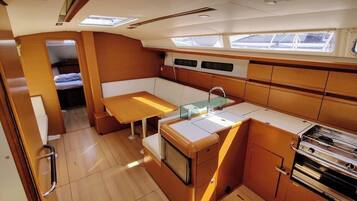 A compact kitchen with a sink, stove, and a small dining area.