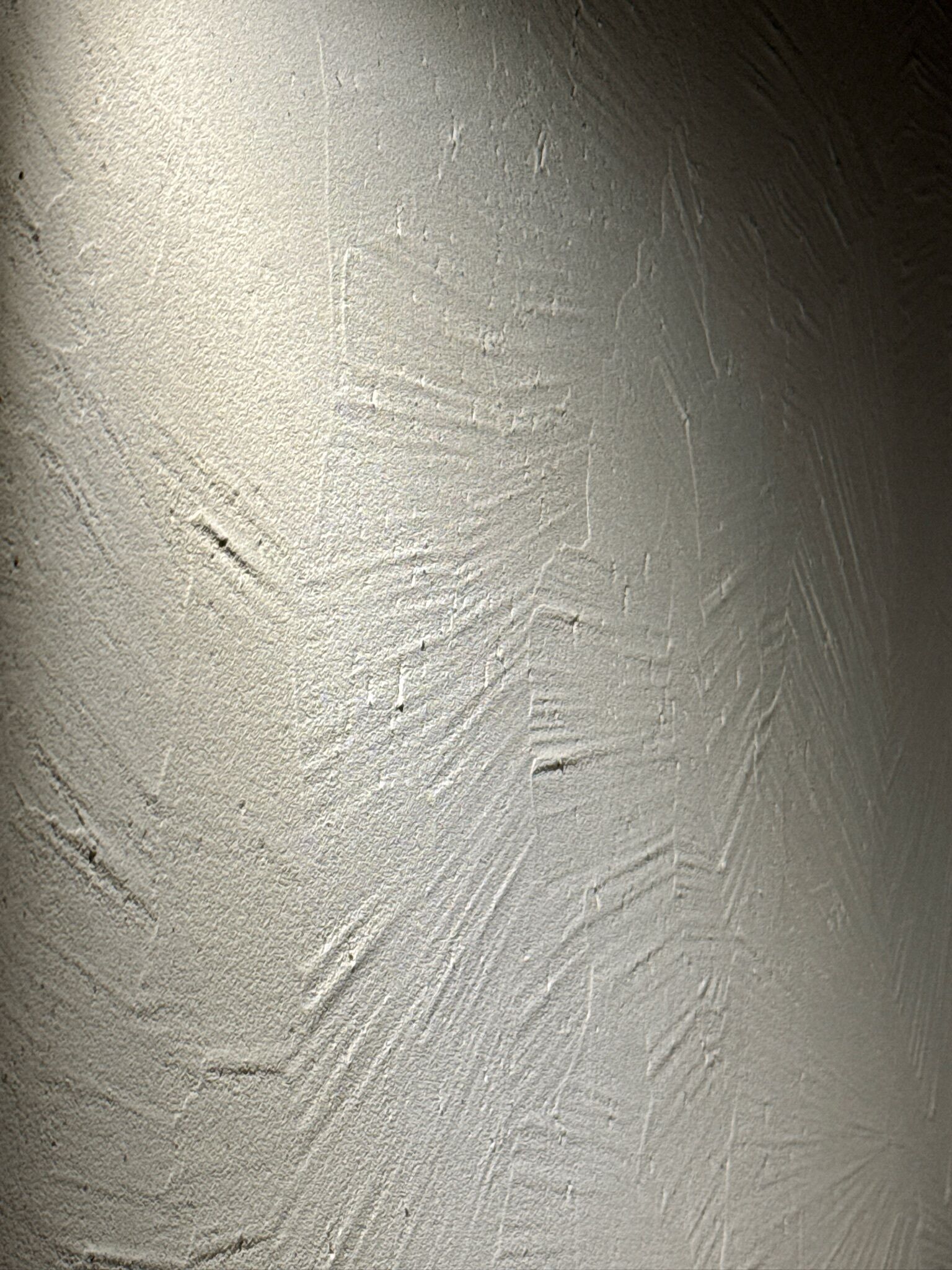 A textured wall with visible scratches and marks.